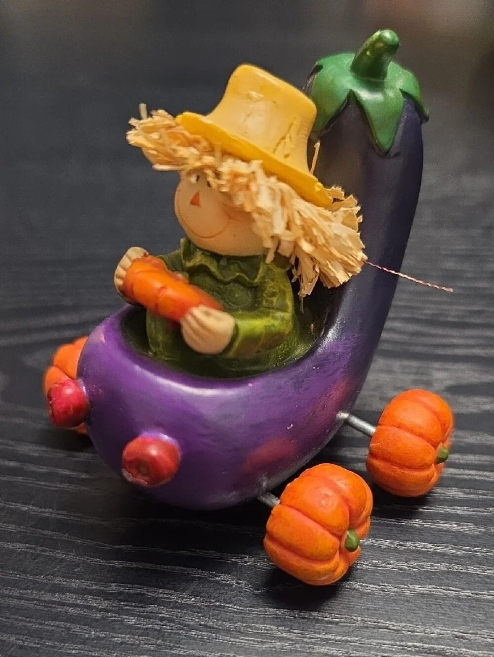 Autumn figurine of a scarecrow in a Eggplant cart